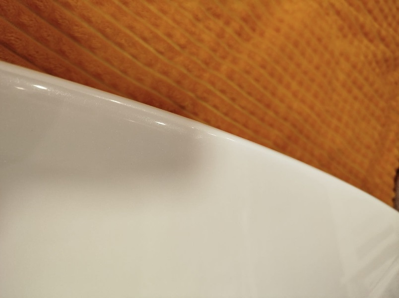 Спойлер — один из немногих элементов стайлинга для Outlander, который вызывает минимум споров — разумеется, с ним лучше, чем без него :)


Со спойлером теперь
Итак, заказал на Али сразу крашеный… По прикидкам некрашеный+покраска (зато точно в цвет) получалась примерно в 15Круб. Окрашеный сразу в белый — 4,3Круб. Решил рискнуть.

Пришел спойлер в транспортную компанию упакованный в пузырчатую пленку основательно, как мумия :)
И, тем не менее — сурпрыз! Заметный залом на внешнем ребре :(


Ну как так?
Ну в той 10-сантиметровой толщины обертке вряд ли так могло получиться, скорее всего сразу таким положили.
В-общем, подал спор (изначально подумал, что оспоренный деньги отдам мастерам, чтобы шпатлевали и красили). Отспорил 1,8Круб. То есть спойлер с дефектом обошелся в 2,5Круб.


По цвету — очень хорошее попадание, разве что на спойлере есть примесь блестящая (наверное, это Polar White или как его там). Но с завода бампера от кузова отличаются существенно сильнее :)
Уже начал у знакомых спрашивать, кто занимается такими работами, никто не признавался… повертел-покрутил в руках и решил кое-что попробовать :)

Сделал технологическое отверстие на внутренней стороне, обмотал изолентой наконечник длинной отвертки, нагрел спойлер в теплой воде, арендовал у жены фен и поставил его на минимальный нагрев.
Ну и изнутри минут за 30 осторожненько выровнял дефект.


Технологическое отверстие и инструмент
Пару недель спойлер отлежался на балконе (проверил, не сработает ли эффект памяти у пластика, когда остынет). Дефект проявился прям минимально (и то, это я знал, куда смотреть). Еще минут 10 повторил процедуру поддавливания и нагрева — и вуаля! Результат отличный.


Живьем вообще место дефекта не найдешь
Следующим квестом оказалось прикрепление.
Дальнейший текст скорее всего будет более интересен ростовчанам…

Беглый поиск стекольного герметика и праймера показал, что это добро обойдется в пару тысяч, не меньше. И потом почти весь герметик все равно на выброс…
Заехал в пару мест, где устанавливают стекла. В одном (федеральная сетка, АвтоТрейд) сразу сказали, что у них нет такой услуги в прайсе, а "внепрайсовые работы" караются штрафом и вплоть до увольнения. Но общались вежливо.

В другом (с довольно живыми социальными сетями, вроде как позиционирующие себя положительно, Автостекла на Вавилова) — просто вышел чувак, ни здрасте, ни досвидания, просто сказал "нет, я это делать не буду" и развернулся. Резкий контраст с социальными сетями. Неприятный осадочек :)

Уже подумал — ну всё, придется самому материалы покупать и звать кого-нибудь на помощь для ровной установки. Но решил заглянуть к еще одним установщикам автостекол. Оказалось, неподалеку есть AG Experts. Ребята красавчики — и пообщались вежливо, и один парень вышел посмотрел-пощупал спойлер. Согласились сделать. Подошли прям очень профессионально — все обезжирили, нанесли праймер, погрели феном и спойлер и крышку багажника, нанесли герметик, приклеили спойлер. И стоимость услуги нормальная — 1,5Круб.


Кепка
В-общем, теперь Белый Бумбр со спойлером.
Считаю, что он делает внешний вид аута существенно гармоничнее. Плюс стоимость доработки получилась ну очень приятной.